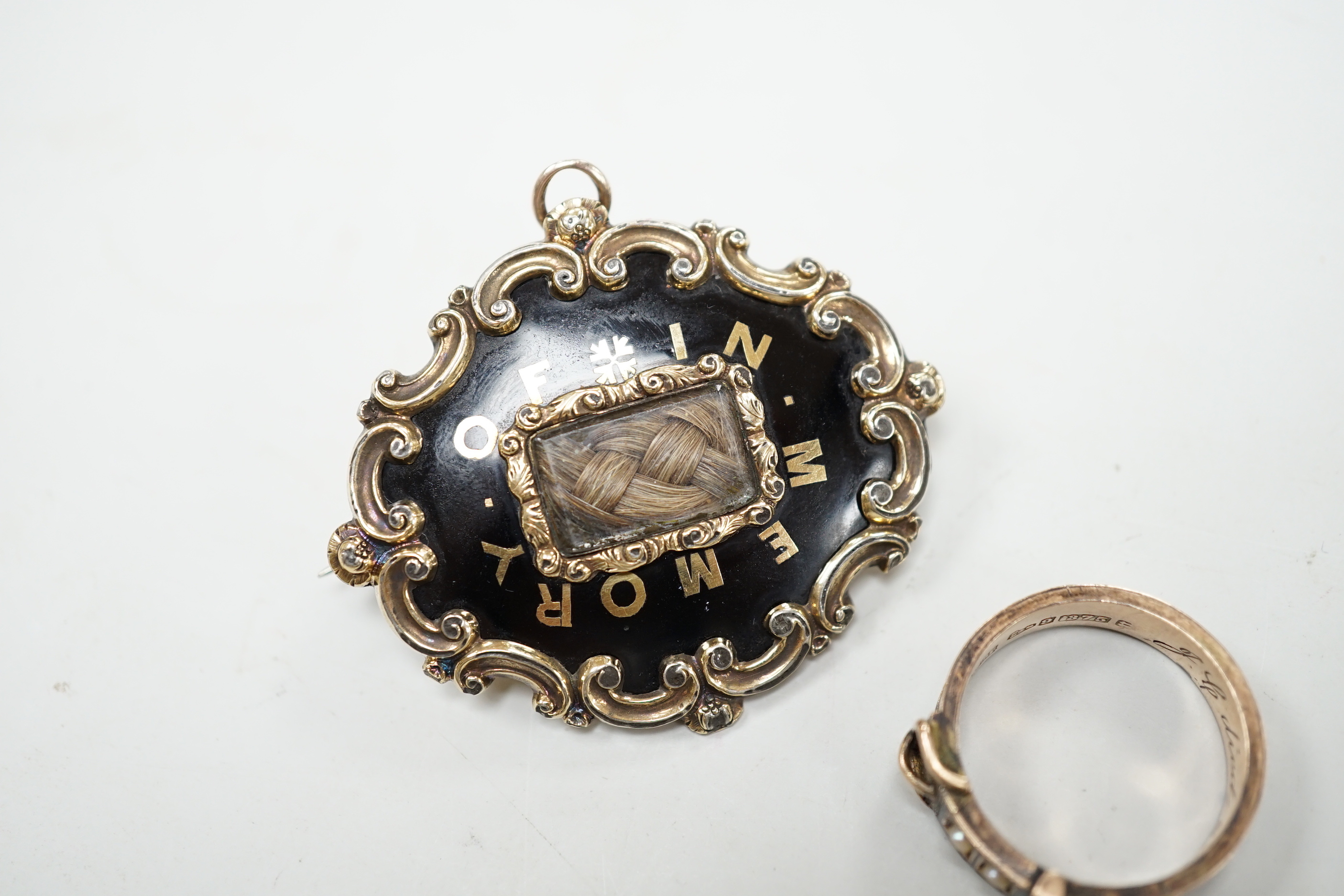 A Victorian 9ct gold, black enamel, plaited hair and seed pearl set mourning buckle ring, size P and a similar yellow metal brooch